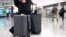  FILE - In this March 26, 2019, photo, a passenger walks in the arrivals terminal at Dulles International Airport in Dulles, Virginia. Newly documents filed in a federal lawsuit claim that U.S. government searches of phones and laptops at airports have increased.