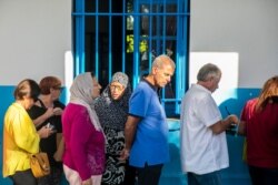 Voters line up outside a polling station during a parliamentary election in La Marsa, outside Tunis, Tunisia, Oct. 6, 2019.