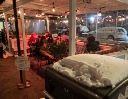 지난 18일 신종 코로나바이러스 재확산으로 방역 조치가 강화된 미국 뉴욕주 맨해튼의 한 식당에서 시민들이 야외 테이블에서 식사하고 있다.
