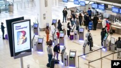 Para pelawat antre check in di Bandara LaGuardia, di Queens, New York, 25 November 2020.