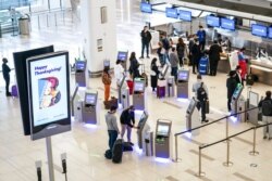 FILE - Travelers wait to check in for flights at LaGuardia Airport, Nov. 25, 2020, in Queens, New York.