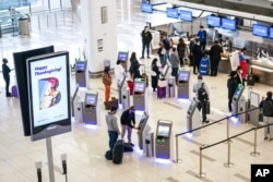 FILE - Travelers wait to check in for flights at LaGuardia Airport, Nov. 25, 2020, in Queens, New York.