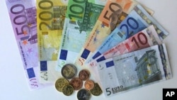 German Euro notes and coins pictured in the regional central bank in Bremen, northwest Germany, Friday, Dec. 14, 2001. On Monday, Dec. 17, the first Euro coins starter kits will start selling all over Germany. The Euro will appear as 5, 10, 20, 50, 10O, 2