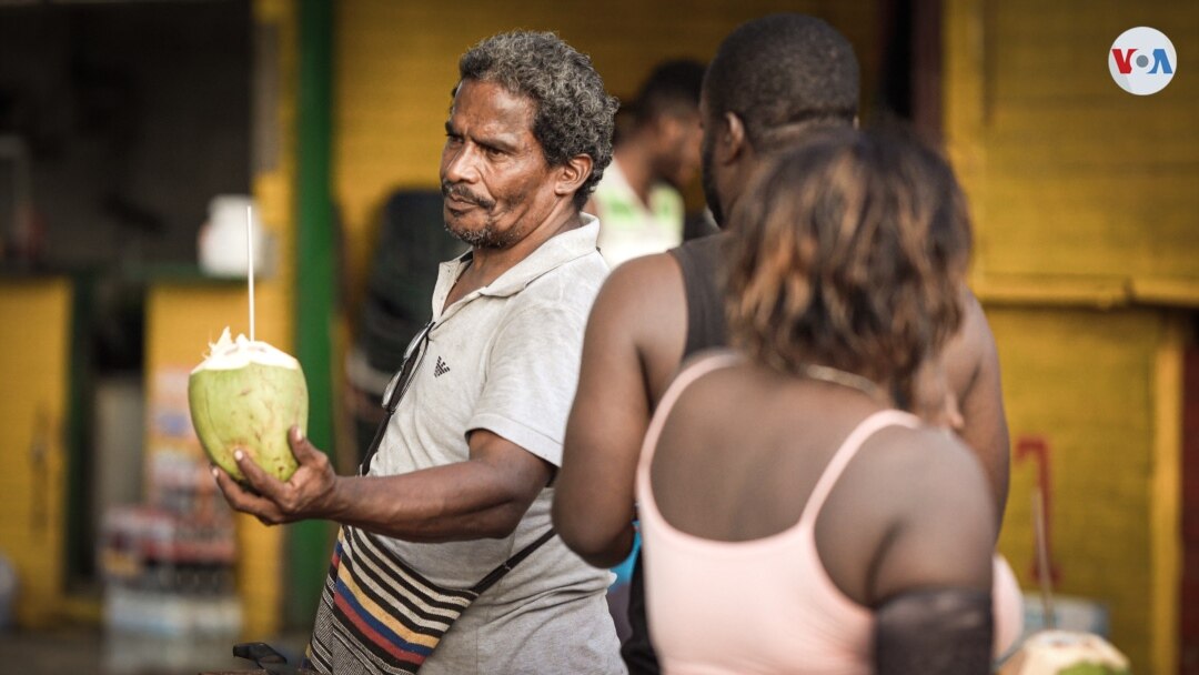 A vendor sells coconut water on the beach in Capurganá, Colombia. (David Hernández/VOA)