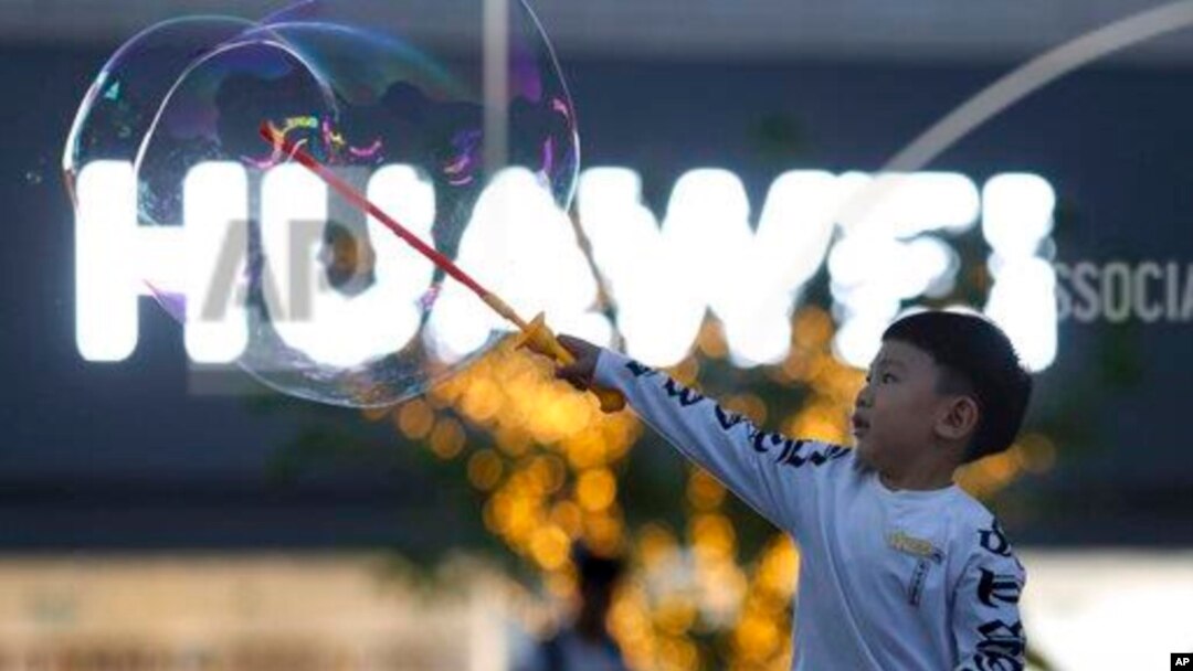 Seorang anak bermain dekat logo Huawei di Beijing, China, 20 Mei 2019.