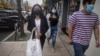 FILE - Emili Prado, 21, left, Christine Cuenca, 18, and Jason Jimenez, 19, campaign to turn out the vote in the largely Hispanic community of Port Richmond in Staten Island, N.Y., Oct. 23, 2020. 