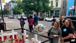 Sabrina Herman, gesturing, visits a makeshift memorial on Aug. 14, 2019, outside Ned Peppers nightclub in the Oregon District entertainment neighborhood where on Aug. 4 a gunman killed nine people, in Dayton Ohio. 