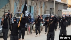 Fighters of al-Qaida linked Islamic State of Iraq and the Levant carry their weapons during a parade at the Syrian town of Tel Abyad, near the border with Turkey, Jan. 2, 2014. 