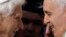 FILE - Pope Emeritus Benedict XVI, left, and Pope Francis exchange greetings at a 2014 meeting. 
