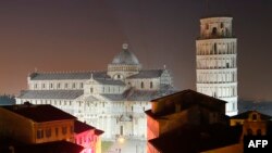 A combination of two pictures shows the leaning tower of Pisa at night (top) and the leaning tower of Pisa colored in green to celebrate Ireland’s national holiday on the eve of the St Patrick’s Day, March 16, 2014.