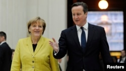 Britain's Prime Minister David Cameron accompanies German Chancellor Angela Merkel as they visit the British Museum in London, Jan. 7, 2015.