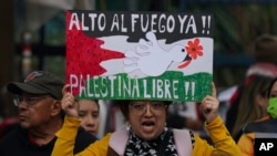 ARCHIVO - Un manifestante sostiene un cartel en favor del alto al fuego en Gaza durante una protesta contra la guerra entre Israel y Hamas, frente a la embajada de Estados Unidos, en la Ciudad de México, el 7 de enero de 2024.