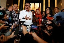 Indonesia's Law and Human Rights Minister Yasonna Laoly talks to journalists with Baiq Nuril Maknun, a school bookkeeper who was jailed after she tried to report sexual harassment, in Jakarta, Indonesia, July 8, 2019.