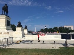 A man caries a bunch of U.S. flags outside the Capitol as preparations for Independence Day Celebrations continue in Washington, DC, July 3, 2019. (Photo by Diaa Bekheet)