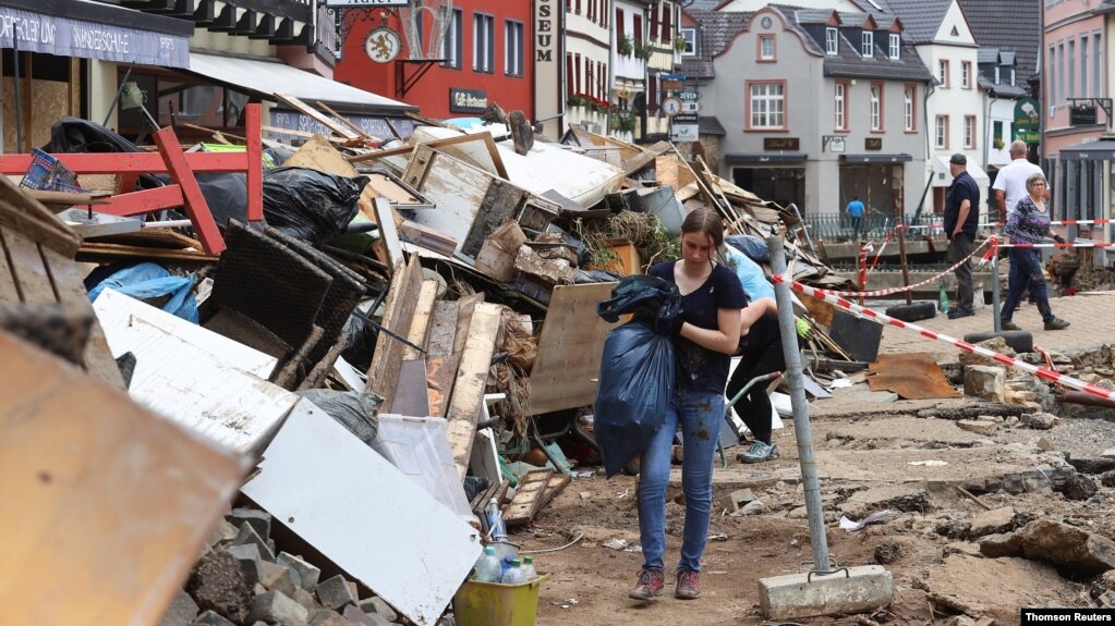 Uma mulher carrega uma sacola em uma área afetada por enchentes causadas por fortes chuvas em Bad Muenstereifel, Alemanha, 19 de julho de 2021.