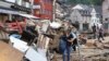 A woman carries a bag in an area affected by floods caused by heavy rainfalls in Bad Muenstereifel, Germany, July 19, 2021.