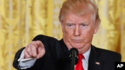 President Donald Trump points to a member of the media as he takes questions during a news conference in the East Room of the White House in Washington, Feb. 16, 2017.