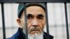 FILE - Uzbek journalist Azimjon Askarov, who has been jailed for life, looks through metal bars in a courtroom during hearings in Bishkek, Kyrgyzstan, Oct. 11, 2016.