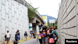 Migrantes venezolanos, entre ellos varios menores de edad, caminan hacia un punto fronterizo con Colombia, en el municipio San Cristóbal, Venezuela, el 12 de octubre de 2020.