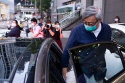 Fung Wai-kong, managing editor and chief opinion writer for shuttered pro-democracy newspaper Apple Daily's English website, who wrote under the pen-name Lo Fung, enters a waiting vehicle after leaving the police headquarters in Hong Kong on June 29.