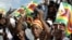 FILE: Zimbabwe political supporters wave flags in Gutu, a rural town 220 Km's south-east of the capital [Harare].