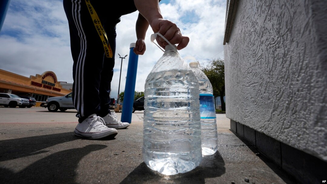 Seorang pria menutup botol yang baru diisi air minum di Irving, Texas, 22 Maret 2024. (Foto: LM Otero/AP Photo)