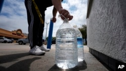 ARCHIVO - Kevin Yu pone un tapón a una botella de agua potable recién llena el viernes 22 de marzo de 2024 en Irving, Texas. Las empresas distribuidoras de agua potable están entrando en una nueva era con un incremento considerable de los estándares de salud.