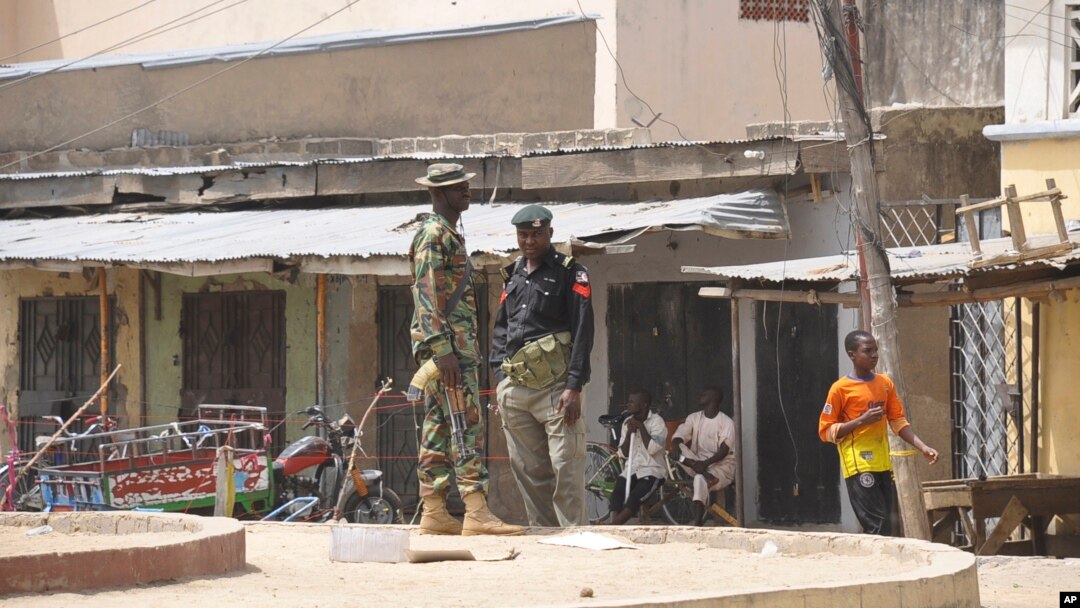 Tentara berjaga-jaga di lokasi ledakan bom di sebuah pasar di Maiduguri, Nigeria (7/3). (AP/Jossy Ola)