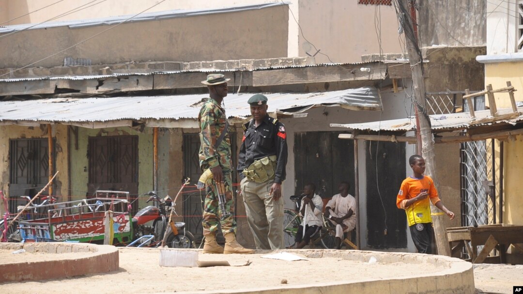 Pasukan keamanan Nigeria menjaga lokasi serangan bunuh diri di sebuah pasar kota Maiduguri, Nigeria (7/3).