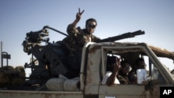 Libyan rebels drive a vehicle mounted with an anti-aircraft gun toward Bin Jawad, August 26, 2011