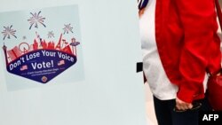 Виборці біля електронної машини для голосування у виборчому центрі штату Невада у Лас-Вегасі, 6 лютого 2024 року, де у результаті переміг варіант "ніхто". Patrick T. Fallon/AFP