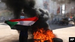 A demonstrator gives the victory sign during a protest, in Khartoum, Sudan, Dec. 19, 2020.