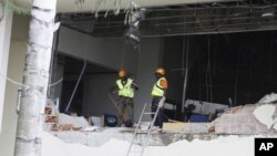 Rescue workers are seen after a bomb blast that ripped through the United Nations offices in the Nigerian capital of Abuja August 26, 2011.