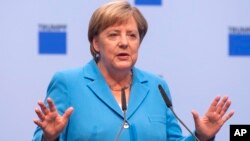 German chancellor Angela Merkel gestures during a discussion with TRUMPF employees in Neukirch, eastern Germany, Aug. 16, 2018.