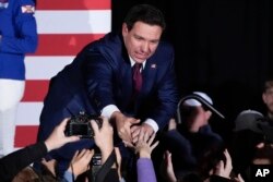 FILE - Republican presidential candidate Florida Gov. Ron DeSantis greets supporters during a caucus night party, January 15, 2024, in West Des Moines, Iowa.
