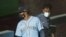 Seattle Mariners' Mallex Smith, left, and Dee Gordon, right, wear masks as they enter the dugout, July 20, 2020, during a "summer camp" baseball scrimmage game in Seattle. 