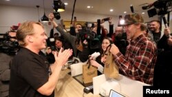 Canopy Growth CEO Bruce Linton applauds after handing Ian Power and Nikki Rose, who were first in line to purchase the first legal recreational marijuana at a Tweed retail store in St John's, Newfoundland and Labrador, Canada October 17, 2018. (REUTERS/Chris Wattie)