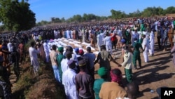 Des gens assistent à des funérailles pour les personnes tuées par des militants présumés de Boko Haram à Zaabarmar, au Nigéria, le dimanche 29 novembre 2020.