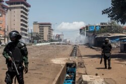 Police officers in riot gear confront demonstrators (not pictured) during mass protests after preliminary election results were announced in Conakry, Guinea, Oct. 23, 2020.