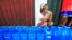FILE - A resident queues with plastic containers to collect drinking water in Rosario.