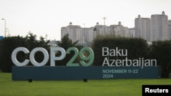 A view shows a sign of the COP29 United Nations Climate Change Conference with a backdrop of the cityscape in Baku, Azerbaijan, Oct. 31, 2024. 