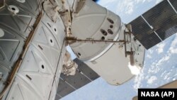 FILE - The SpaceX Dragon spacecraft is shown docked at the International Space Station.