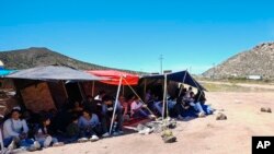 ARCHIVO: Un grupo de personas esperan a ser procesadas después de cruzar la frontera entre México y Estados Unidos para solicitar asilo, el miércoles 17 de abril de 2024, cerca de Jacumba, California. 