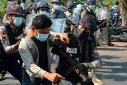A demonstrator is detained by police officers during a protest against the military coup in Mawlamyine, Myanmar, Feb. 12, 2021. (Than Lwin Times/Handout via Reuters)