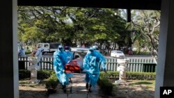 Petugas kota Sri Lanka membawa jenazah korban COVID-19 untuk dikremasi di Kolombo, Sri Lanka, Jumat, 11 Desember 2020. (Foto: AP/Eranga Jayawardena)