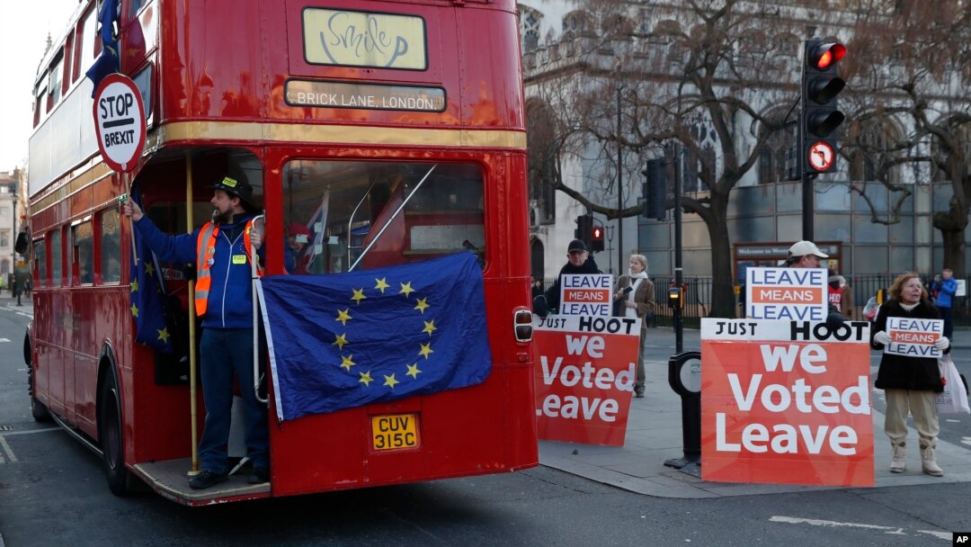 Demonstran Anti-Brexit menyewa sebuah bus kota London melewati para demonstran pendukung Brexit di depan gedung parlemen Inggris di London, Senin (28/1). 