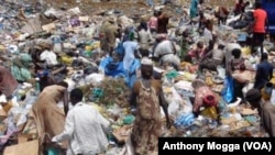 South Sudanese pick through a sea of trash outside Juba, looking for plastic bottles that they can exchange for money at a local NGO. 