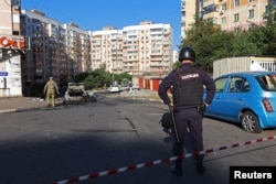 FILE - A police officer stands guard at the site of recent shelling - which local authorities called a Ukrainian military strike - in Belgorod, Russia, Sept. 16, 2024.