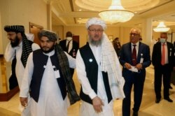 Deputy Head of Political Office of the Taliban Abdul Salam Hanafi, center, heads to attend the opening session of the peace talks between the Afghan government and the Taliban in Doha, Qatar, Saturday, Sept. 12, 2020.