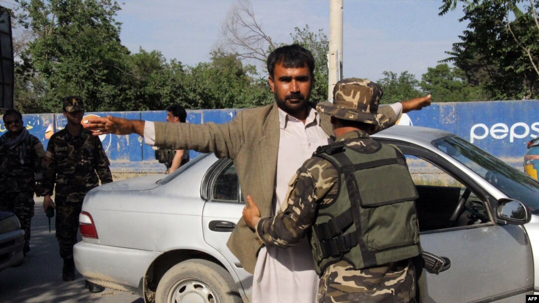 Petugas keamanan Afghanistan menggeledah pejalan kaki di titik pemeriksaan, Provinsi Kunduz.
